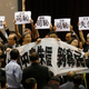 Pro-democracy lawmakers hold up placards that say “shameful” while China’s deputy general secretary of the National People’s Congress standing committee speaks in Hong Kong on Sept 1.